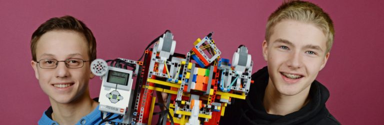 Zwei Schüler mit Roboter aus Legotechniksteinen