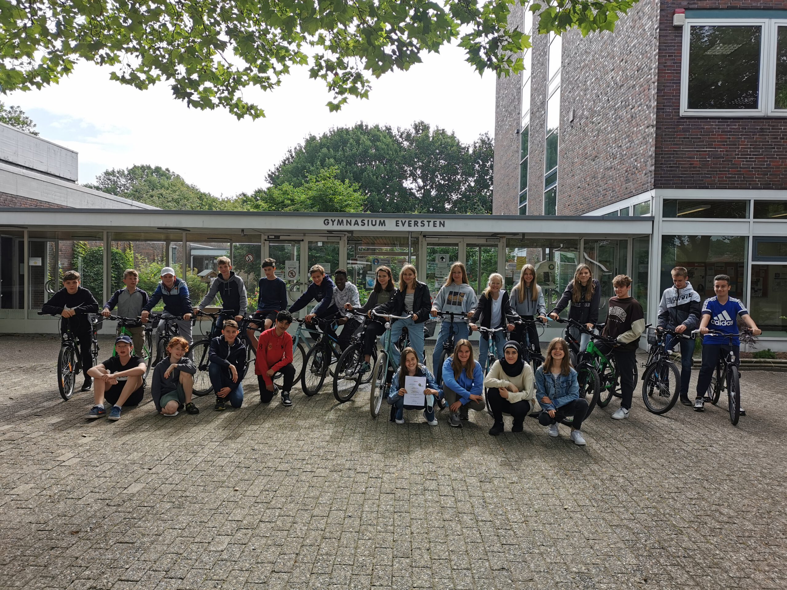 Klasse mit Auszeichnung und Fahrrädern vor Schule