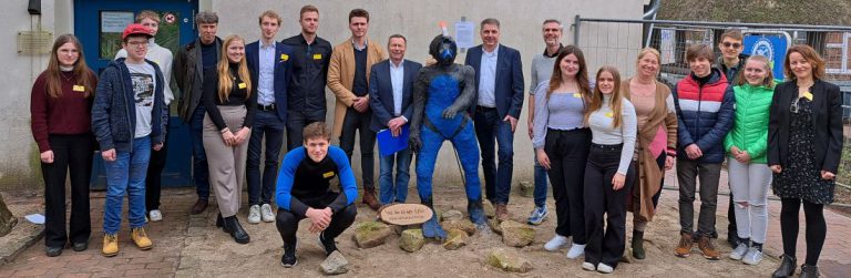 Schülergruppe mit Skulptur