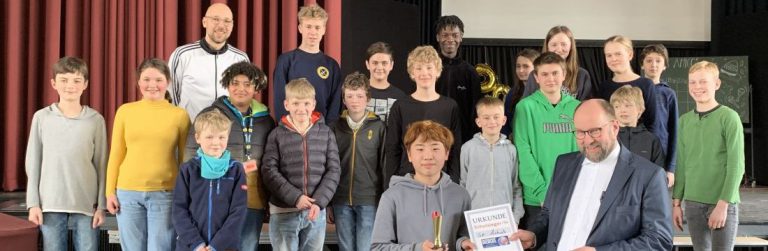 Herr Hawighorst und Leder mit einigen Schüler und Sei wird die Urkunde überreicht