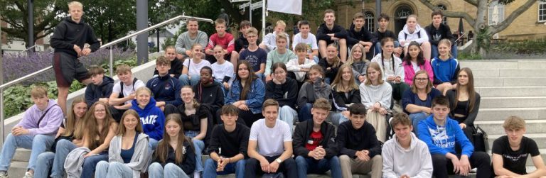 zahlreiche Schüler auf Treppe sitzend