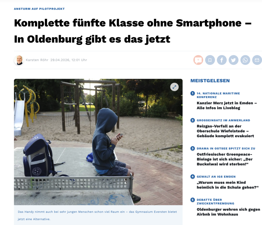 Kind mit Handy auf Tischtennisplatte