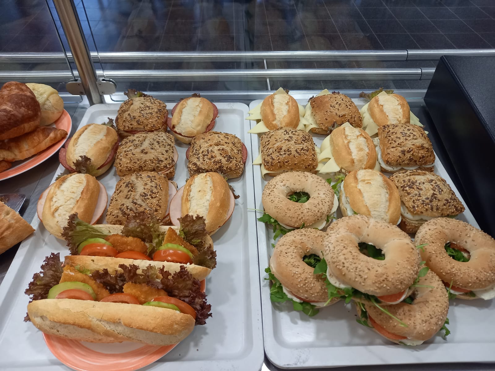 Auslage mit verschiedenen belegten Brötchen, Bagels und Baguette