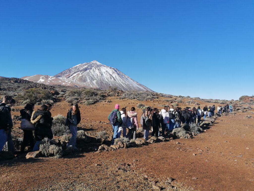 zahlreiche Schüler hintereinander gehend vor Berg