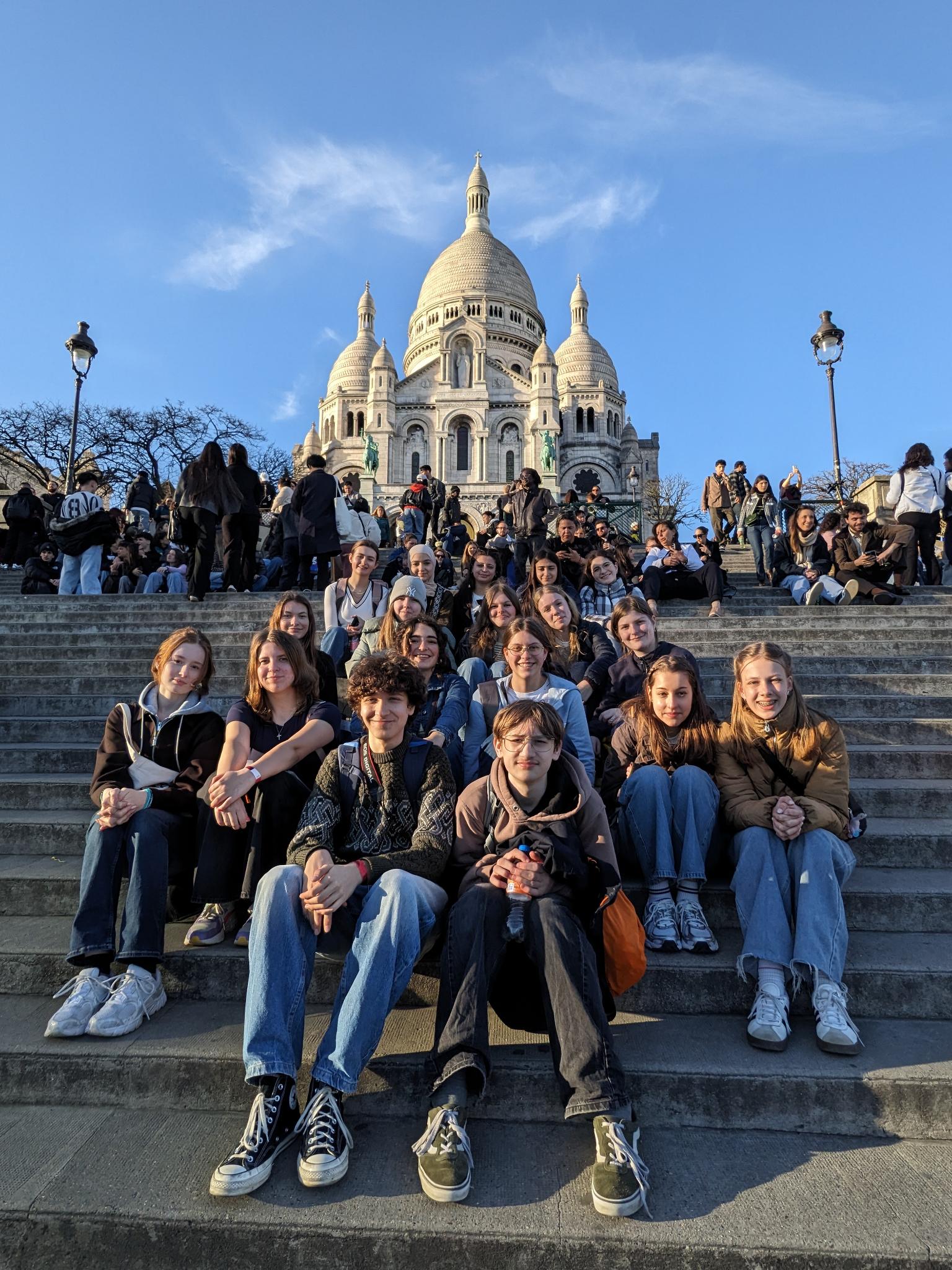 zahlreiche Schülerinnen und Schüler des 9. Jahrgangs vor Sacré-Cœur de Montmartre auf der Treppe